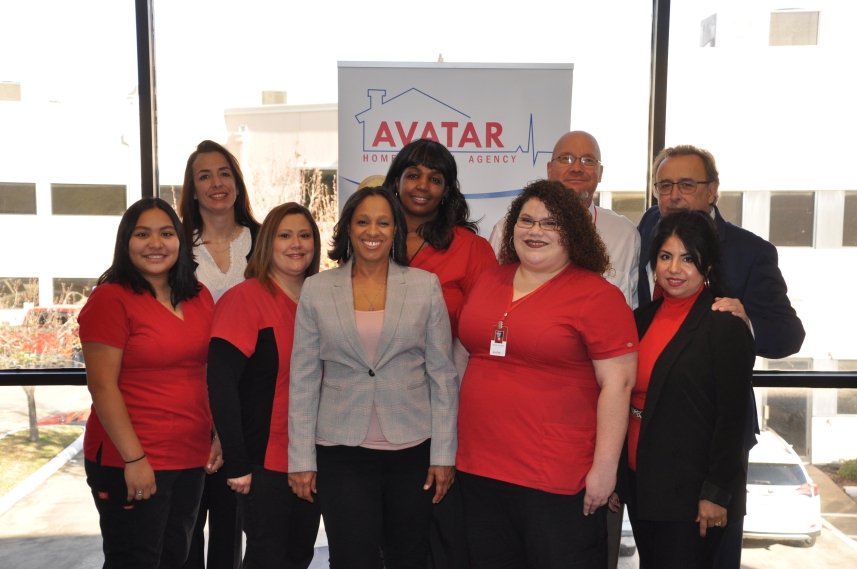 Avatar Home Agency team photo. Group of diverse staff members in red shirts and professional attire smiling.