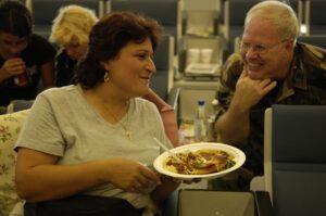 Woman with food plate talking to man in camouflage shirt. Giving back to the community.