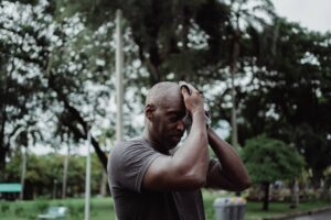 Man wiping sweat after exercising in the heat, staying cool this summer.