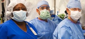 Surgical team in masks and surgical gowns, ready for an operation.