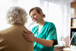 Nurse assisting elderly patient in the comfort of their own home.
