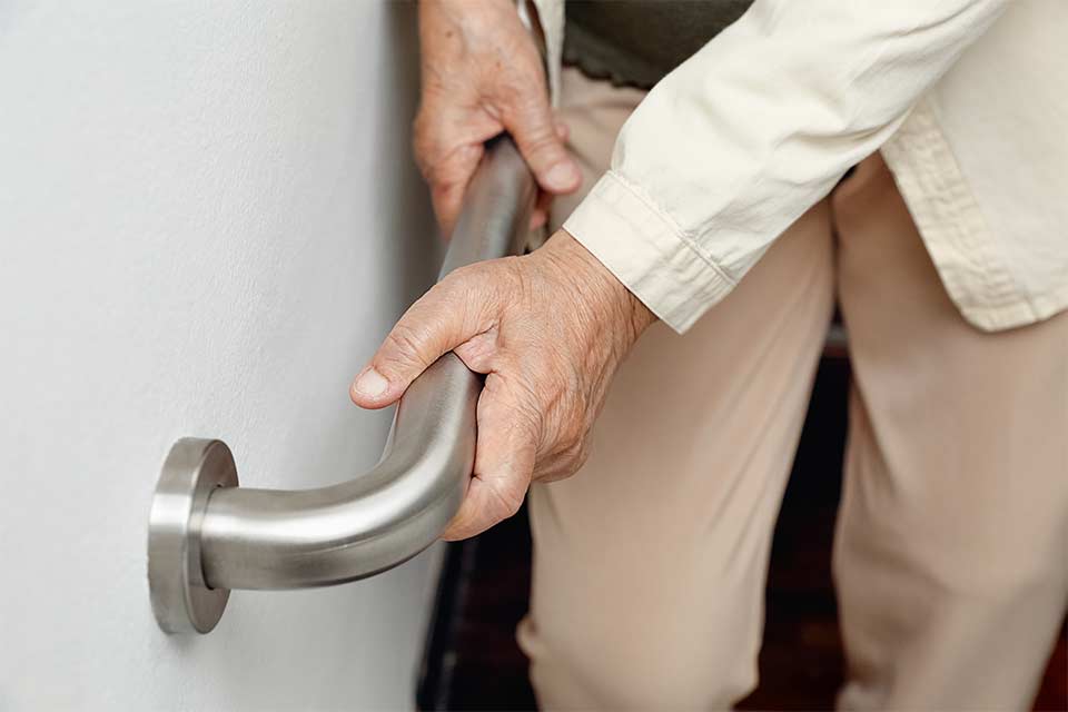 Senior holding a handrail for safety on stairs. Preventing falls.