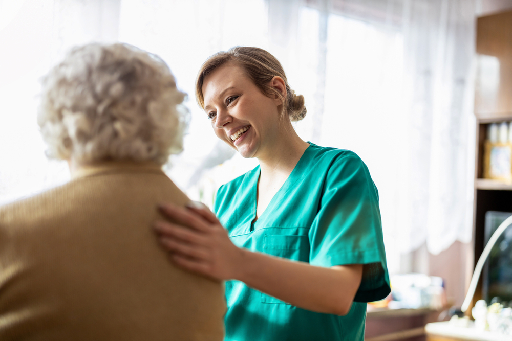 Nurse assisting elderly patient in the comfort of their own home.